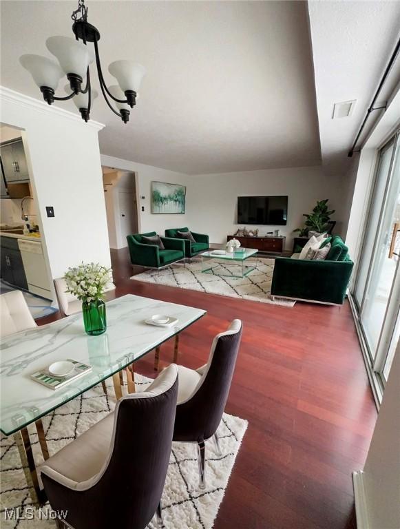 dining room with an inviting chandelier and dark wood-type flooring