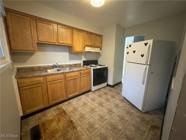 kitchen featuring a textured ceiling, sink, and white appliances