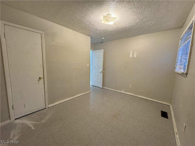 spare room with a textured ceiling