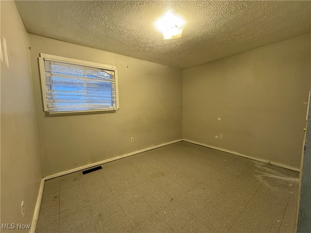 unfurnished room featuring a textured ceiling