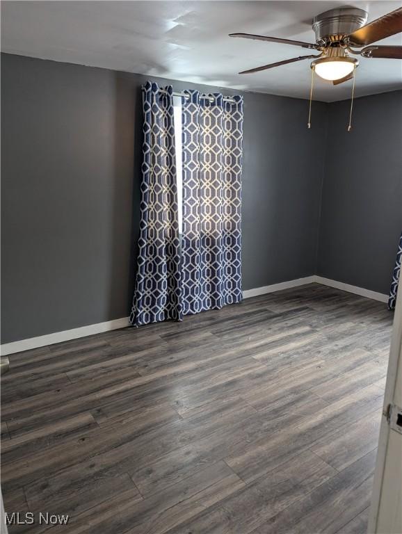 spare room with ceiling fan and dark wood-type flooring