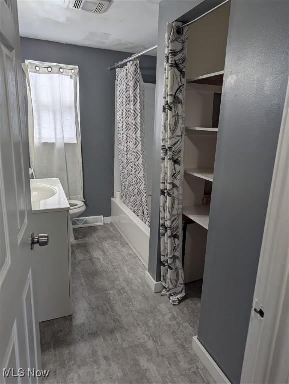 full bathroom featuring vanity, toilet, wood-type flooring, and shower / bath combo