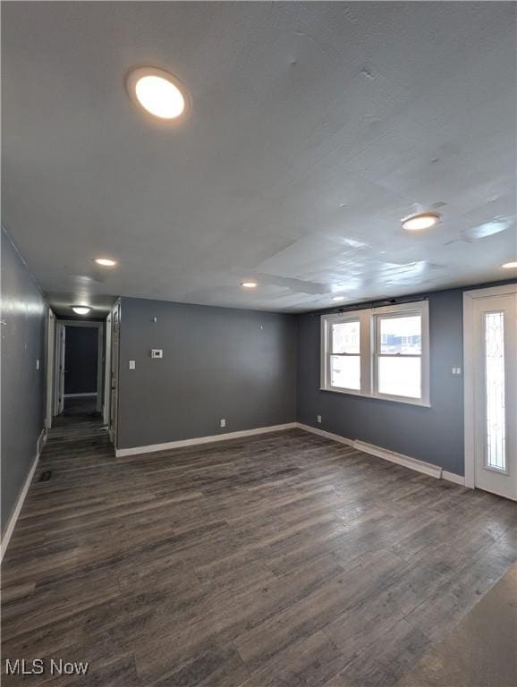 basement with dark hardwood / wood-style flooring and a wealth of natural light