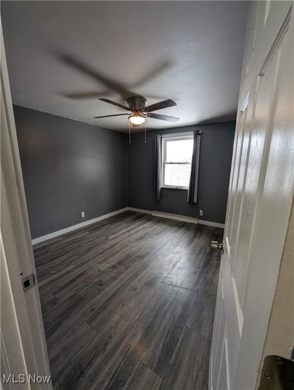 spare room featuring dark hardwood / wood-style flooring and ceiling fan