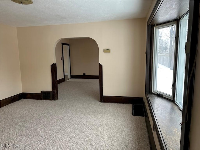 carpeted spare room featuring a textured ceiling