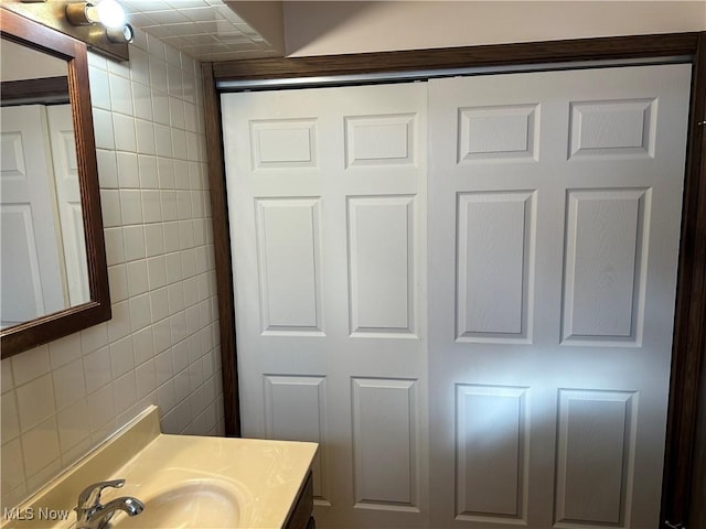 bathroom with vanity and tile walls