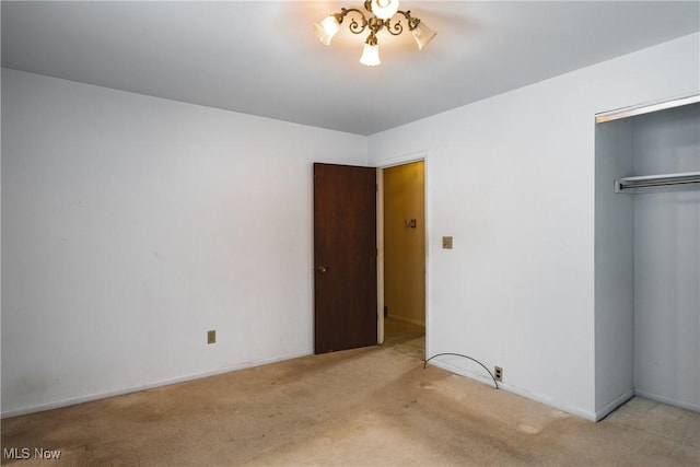 unfurnished bedroom with light carpet and a closet