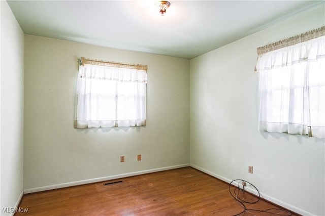 unfurnished room with wood-type flooring