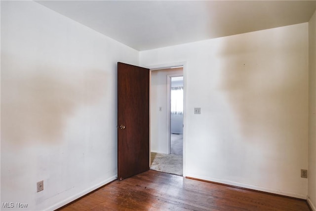 unfurnished room featuring dark wood-type flooring