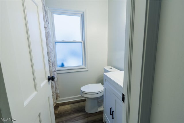 bathroom featuring vanity, a healthy amount of sunlight, toilet, and wood-type flooring