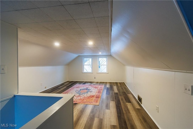 additional living space featuring dark hardwood / wood-style flooring and lofted ceiling