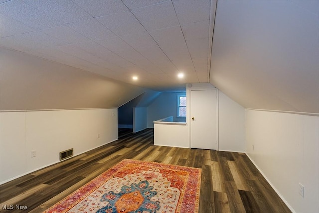 additional living space with dark hardwood / wood-style flooring and vaulted ceiling