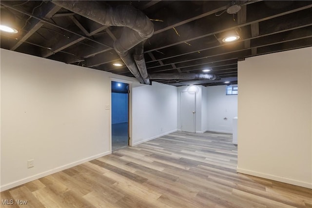 basement with light hardwood / wood-style floors