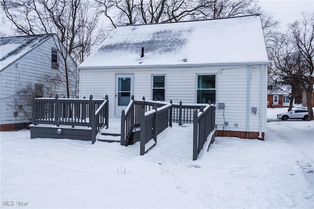 snow covered property featuring a wooden deck