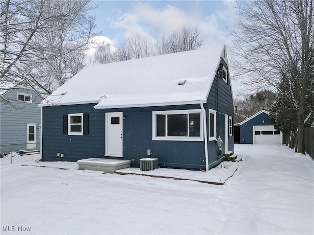 snow covered property featuring an outbuilding and a garage