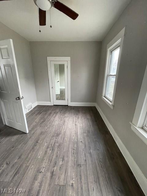 unfurnished room with dark wood-type flooring and ceiling fan