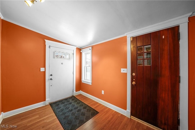 entrance foyer with wood-type flooring, crown molding, and vaulted ceiling