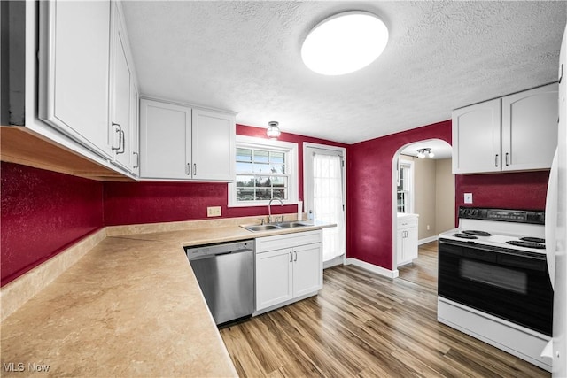 kitchen featuring dishwasher, sink, light wood-type flooring, white electric range oven, and white cabinetry