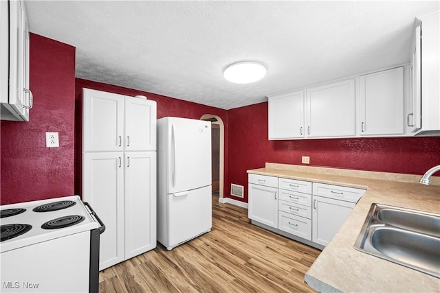 kitchen featuring white cabinetry, sink, light hardwood / wood-style floors, a textured ceiling, and white appliances