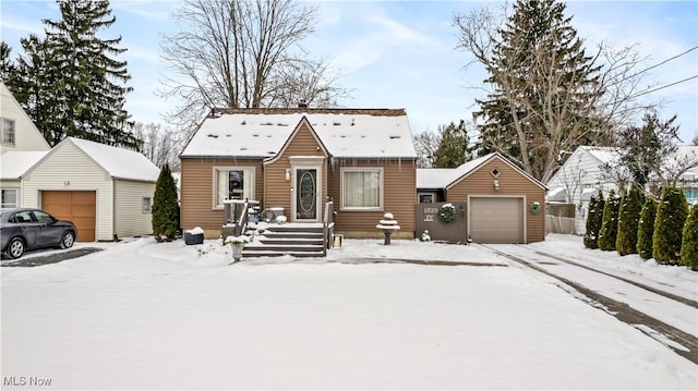 view of front of house with a garage and an outbuilding