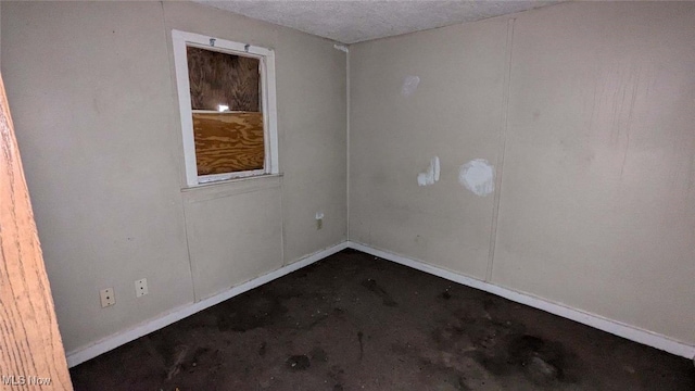 unfurnished room with concrete flooring and a textured ceiling