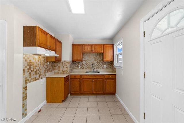 kitchen featuring decorative backsplash, light tile patterned floors, and sink