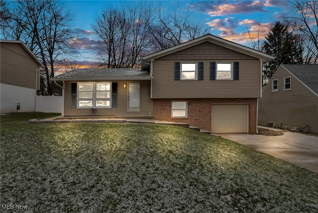 split level home with a yard and a garage