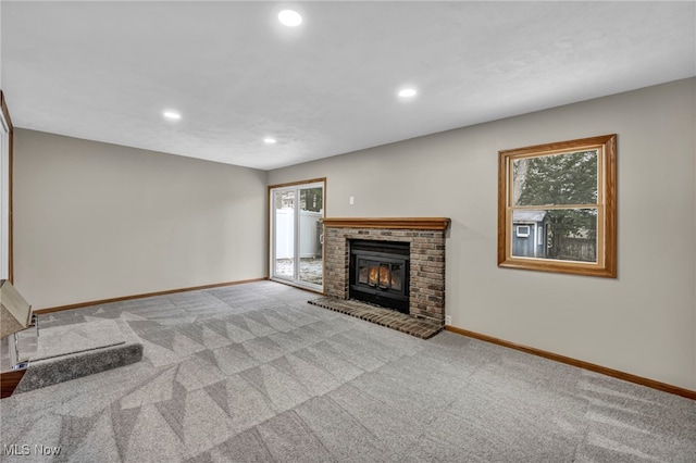 unfurnished living room featuring a fireplace and light colored carpet