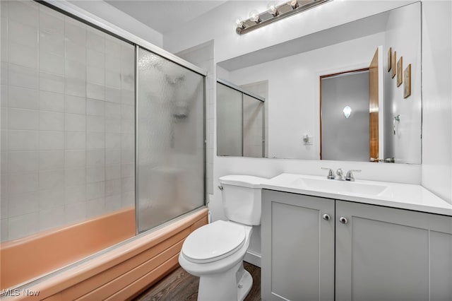 full bathroom with vanity, enclosed tub / shower combo, and toilet