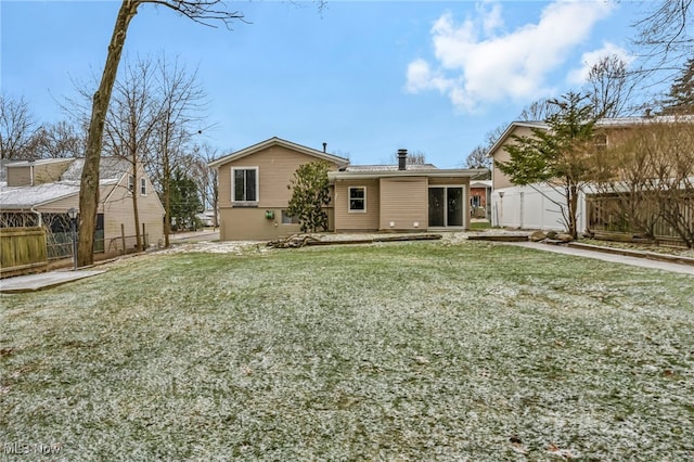 rear view of house featuring a yard