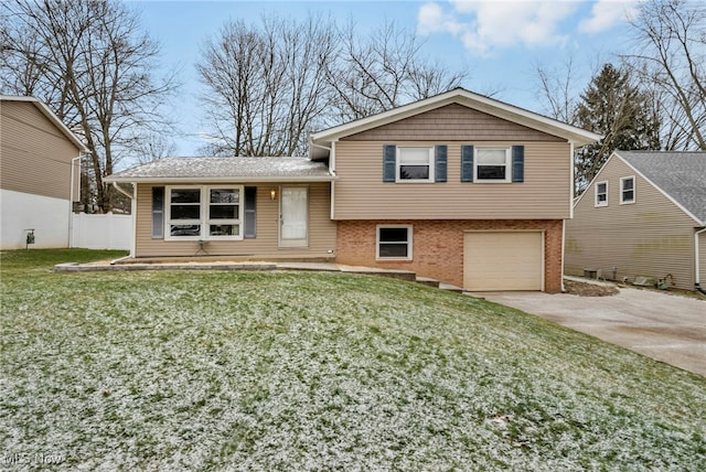 split level home with a garage and a front lawn