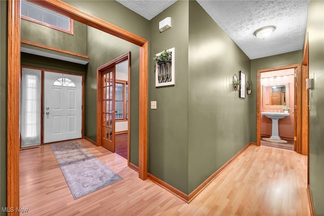 foyer with a textured ceiling and light hardwood / wood-style flooring