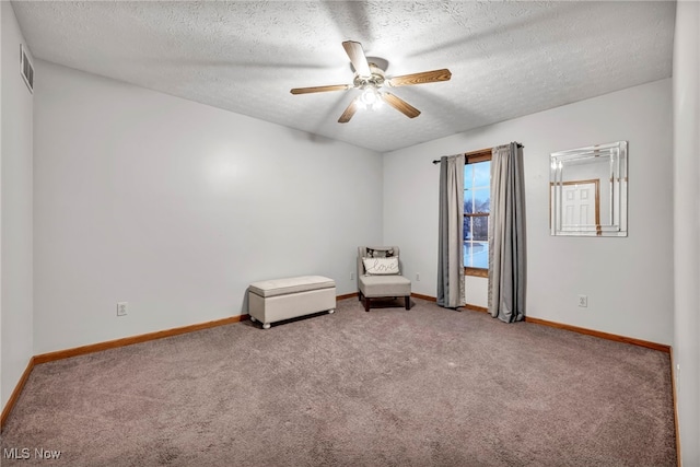 unfurnished room with carpet flooring, ceiling fan, and a textured ceiling