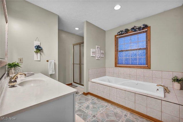 bathroom with vanity and shower with separate bathtub