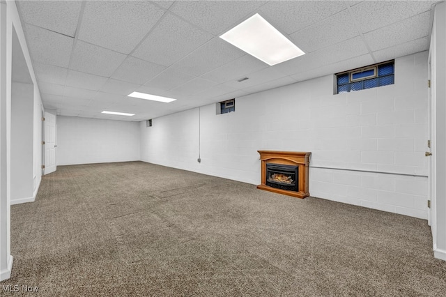 basement featuring carpet and a paneled ceiling