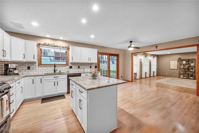 kitchen with a center island, white cabinets, sink, ceiling fan, and dishwashing machine