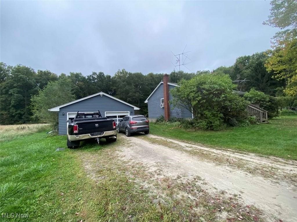 view of front facade featuring a garage, an outbuilding, and a front yard