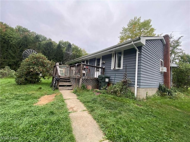 view of front of home with a front yard, a deck, and cooling unit