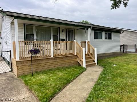 view of front of home featuring covered porch and a front lawn