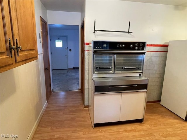 kitchen featuring oven and light wood-type flooring