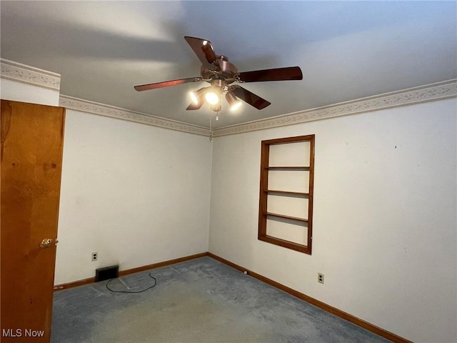 carpeted spare room with ceiling fan and built in shelves