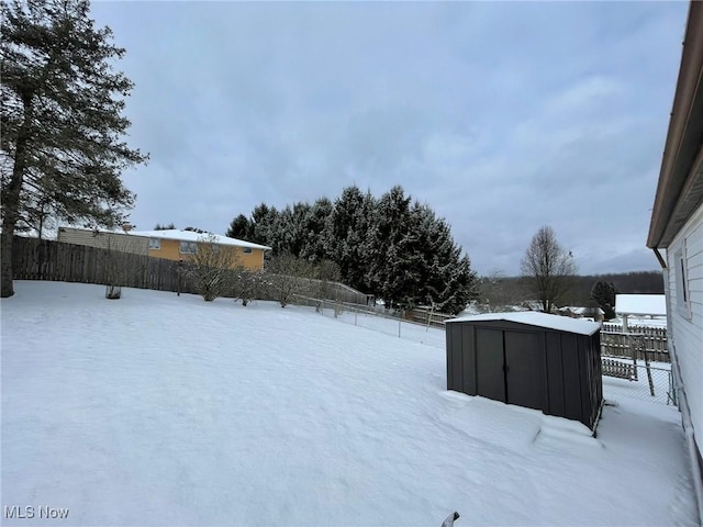 yard covered in snow with a storage shed