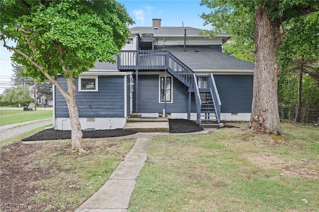 rear view of property with a deck and a lawn