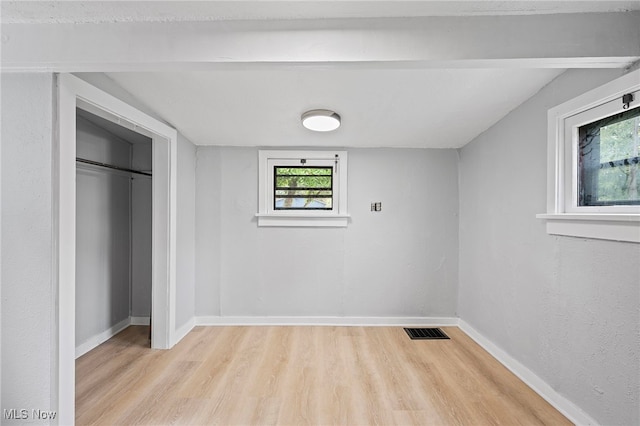 unfurnished bedroom with light wood-type flooring and a closet