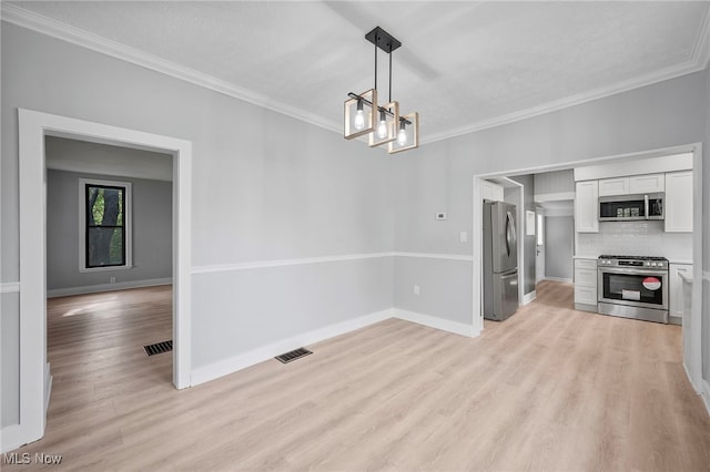 kitchen with backsplash, an inviting chandelier, white cabinets, hanging light fixtures, and appliances with stainless steel finishes