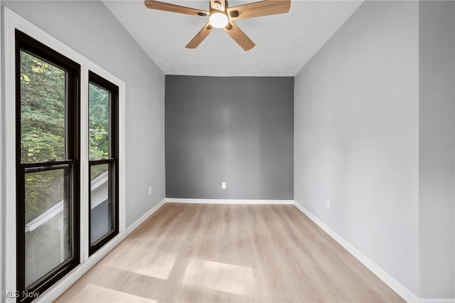 spare room with ceiling fan, light hardwood / wood-style flooring, and a textured ceiling