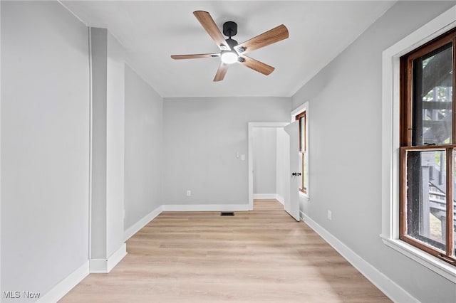 empty room with ceiling fan and light hardwood / wood-style flooring