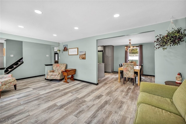 living room featuring a notable chandelier and light wood-type flooring