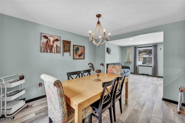 dining room with a chandelier and light hardwood / wood-style flooring