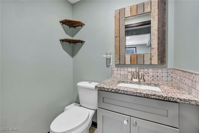 bathroom featuring backsplash, vanity, and toilet